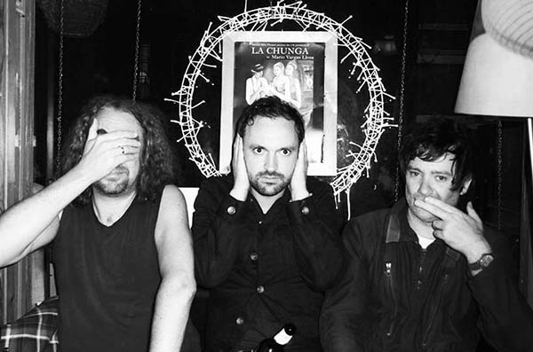 Three men in a pub doing 3 Wise Monkeys