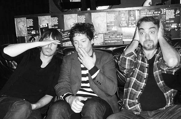 Three men in a pub doing 3 Wise Monkeys