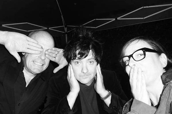 Three people in a pub garden doing 3 Wise Monkeys