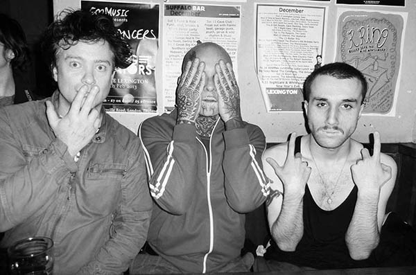 Three men in a pub doing 3 Wise Monkeys