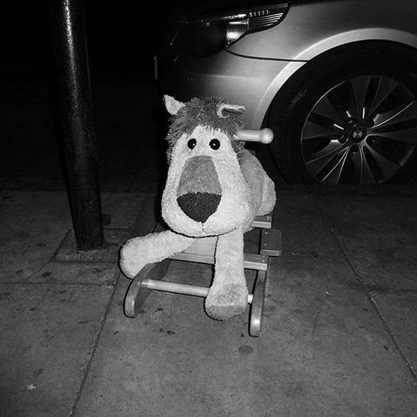 Children's toy rocking lion abandoned at the side of the road