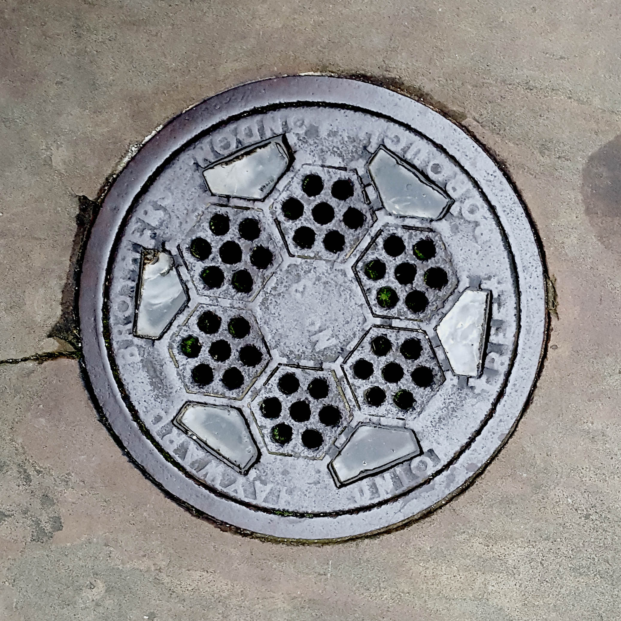 Manhole Cover, London - Cast iron surround inscribed with Hayward Brothers Union Street Borough London - Inner pattern of hexagonal shapes with holes and half hexagonal glass inserts