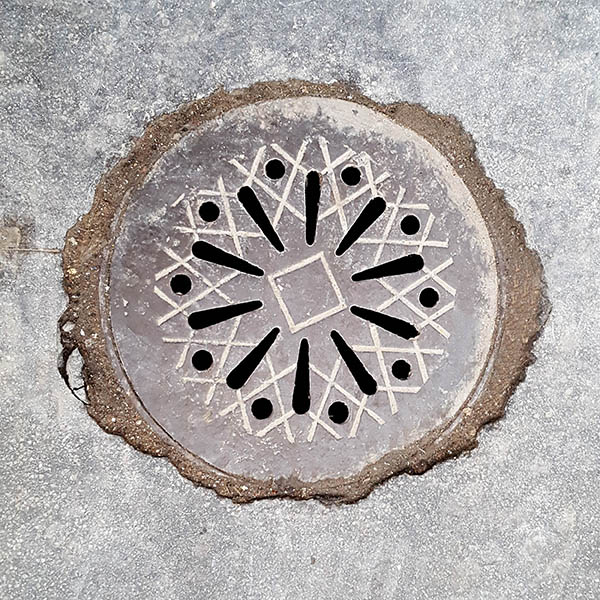 Manhole Cover, London - Cast iron with decorative lines and cut outs