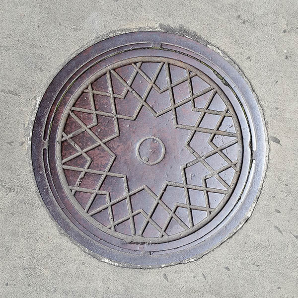 Manhole Cover, London - Cast iron surround with criss cross star pattern and circle