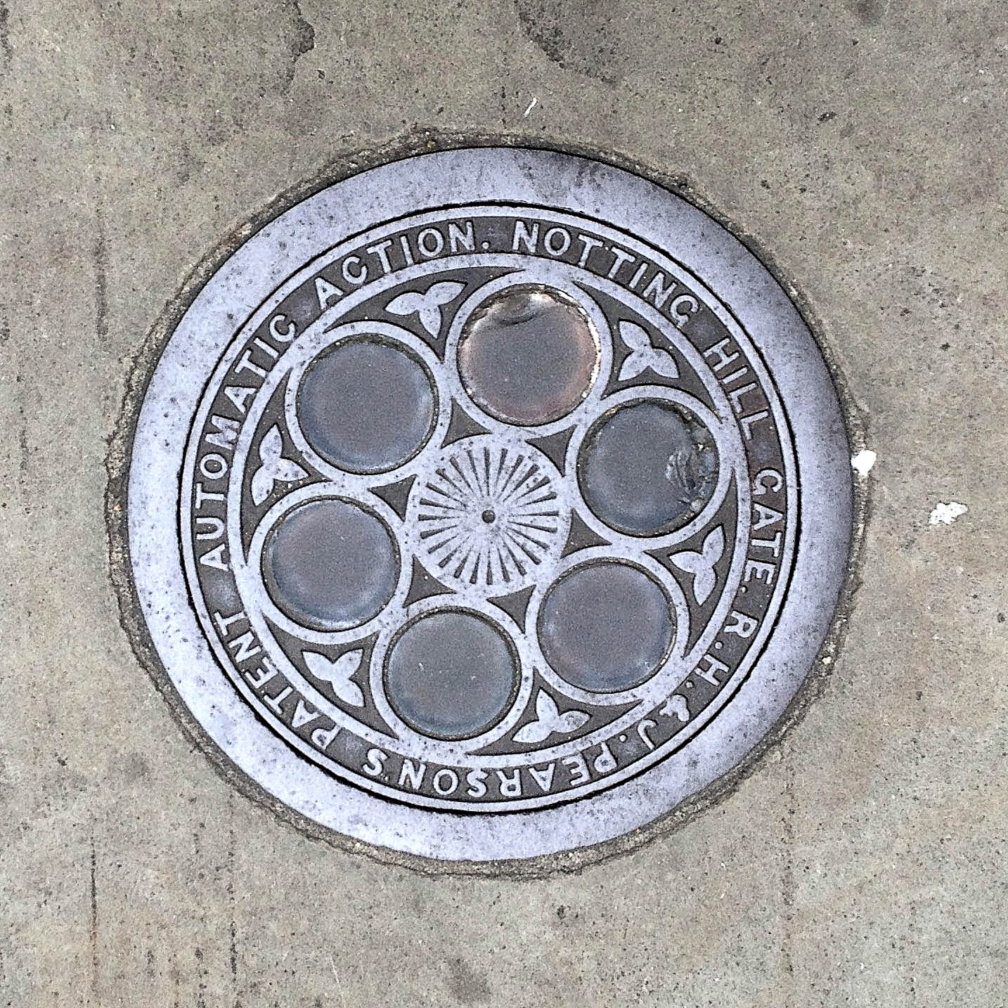 Manhole Cover, London - Cast iron surround inscribed with R H & J Pearson's patent Automatic Action. Notting Hill Gate - Inner, six glass circular inserts