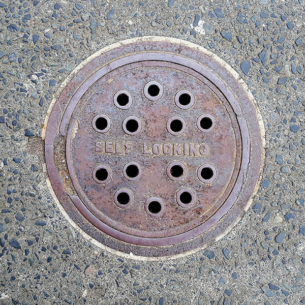 Manhole Cover, London - Cast iron, inscribed with Self Locking and a pattern of fourteen holes