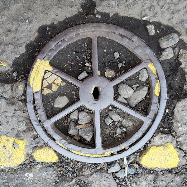 Manhole Cover, London - Cast iron surround with six segments of dirt and stones