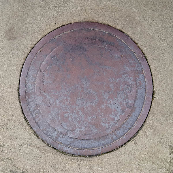 Manhole Cover, London - Cast iron worn with age