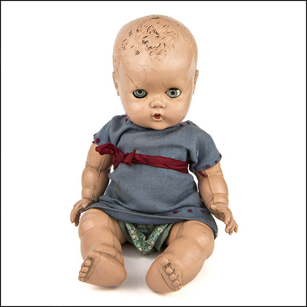 Vintage hard plastic doll wearing a blue dress