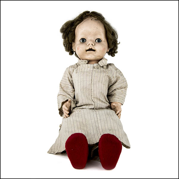 Vintage hard plastic doll wearing beige striped dress