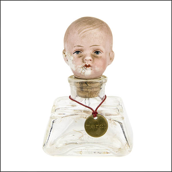 Vintage bisque doll's head stopper in clear glass ink bottle