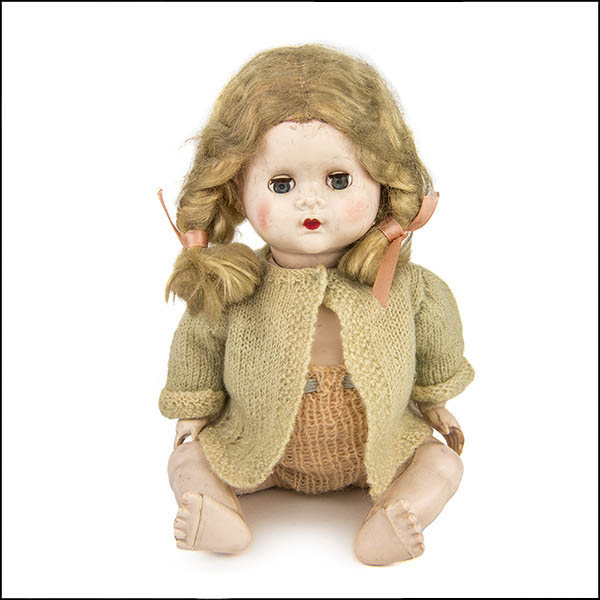 Vintage hard plastic doll with knitted green cardigan and peach knickers