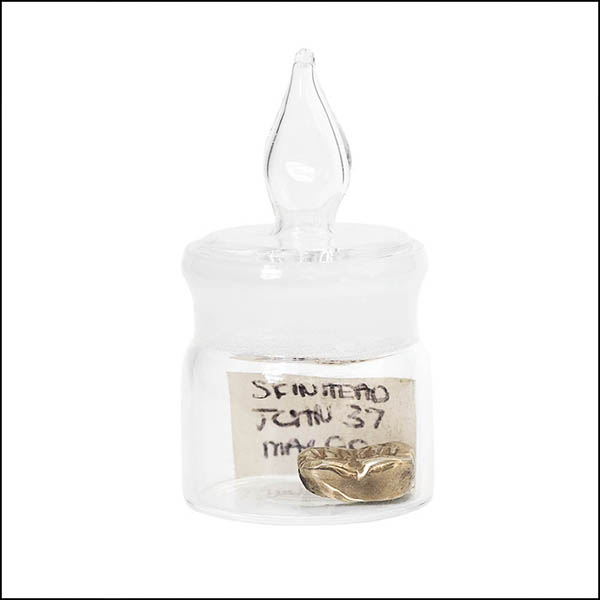 Gold tooth in glass pot - part of tooth collection