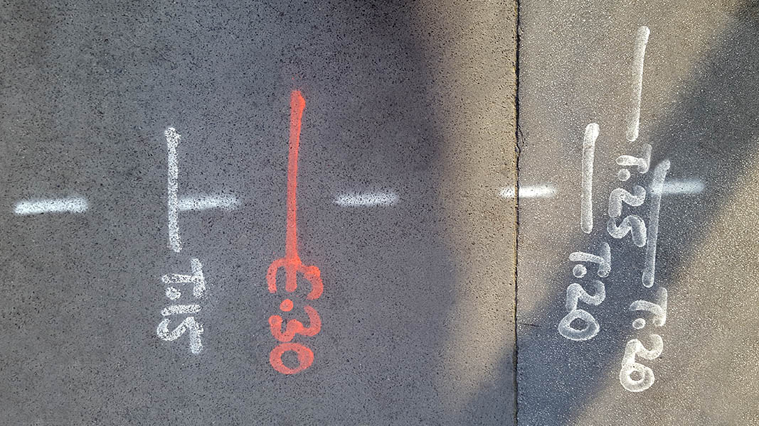 Pavement markings - spray painted squiggles on paving stones - Red and white letters and lines