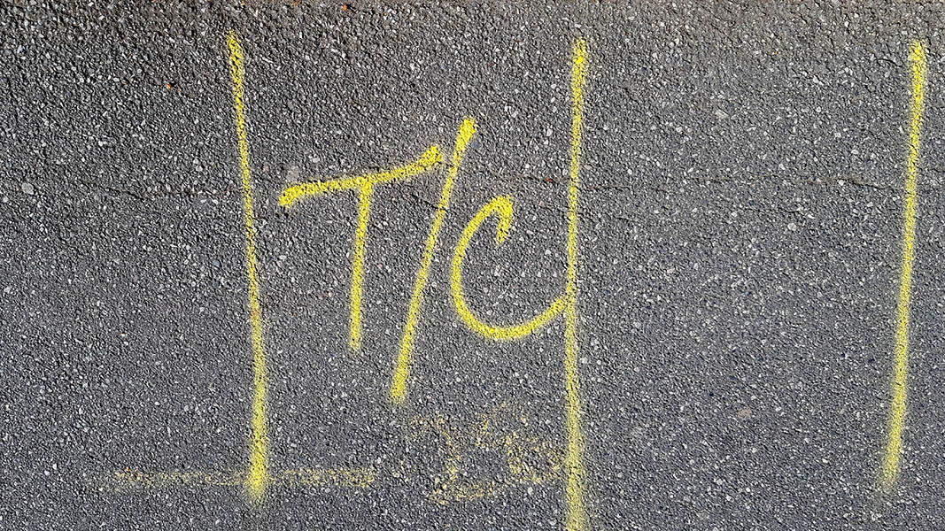 Pavement markings - spray painted squiggles on tarmac - Yellow letters and lines