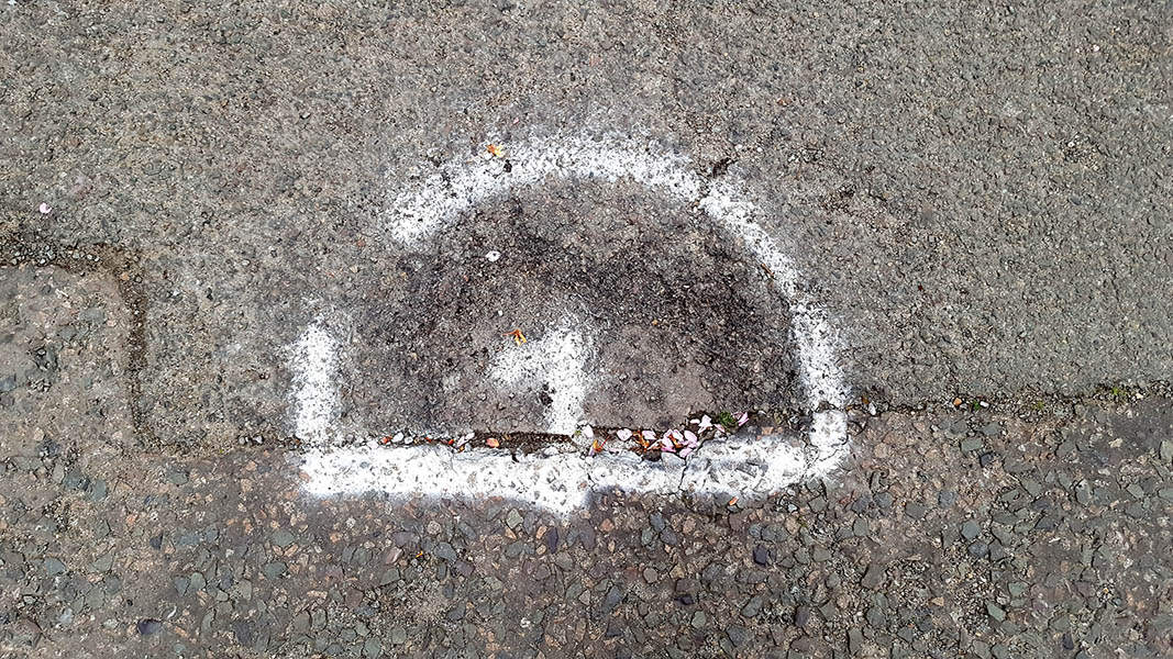 Pavement markings - spray painted squiggles on tarmac - White D