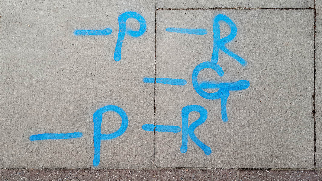 Pavement markings - spray painted squiggles on paving stones - Blue lines and writing