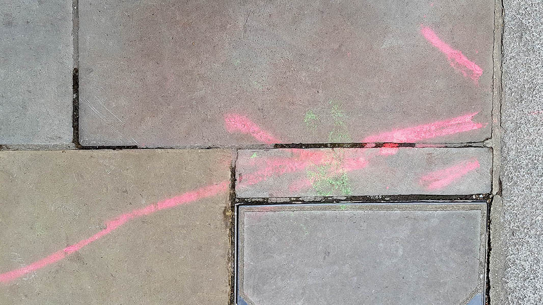 Pavement markings - spray painted squiggles on paving stones - Red lines