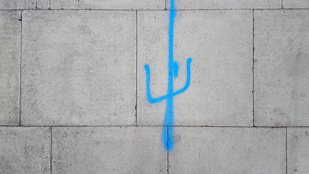 Pavement markings - spray painted squiggles on paving stones - Blue vertical lines
