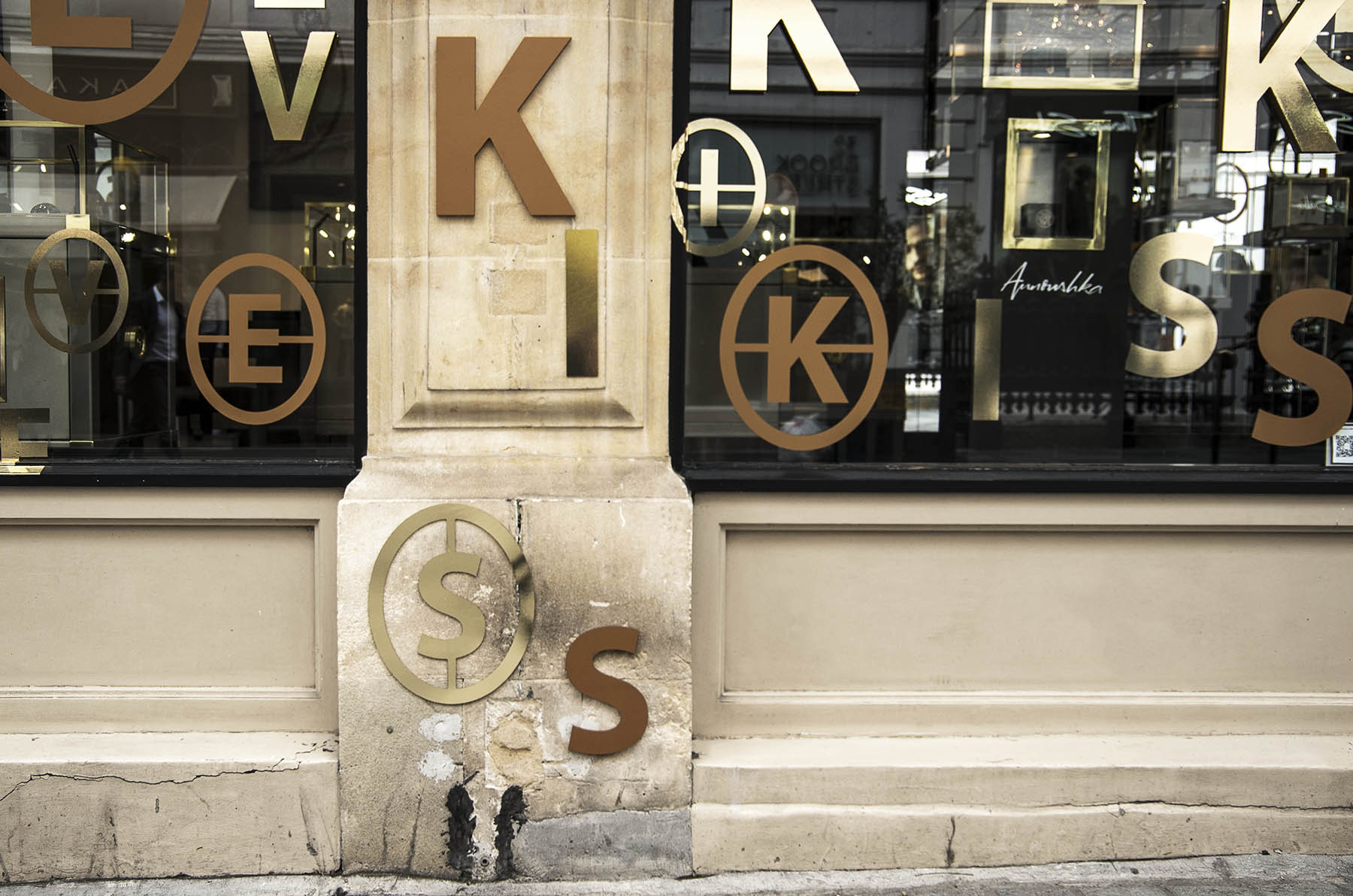Annoushka Initials window display - gold and copper letters spelling Kiss on wall and windows